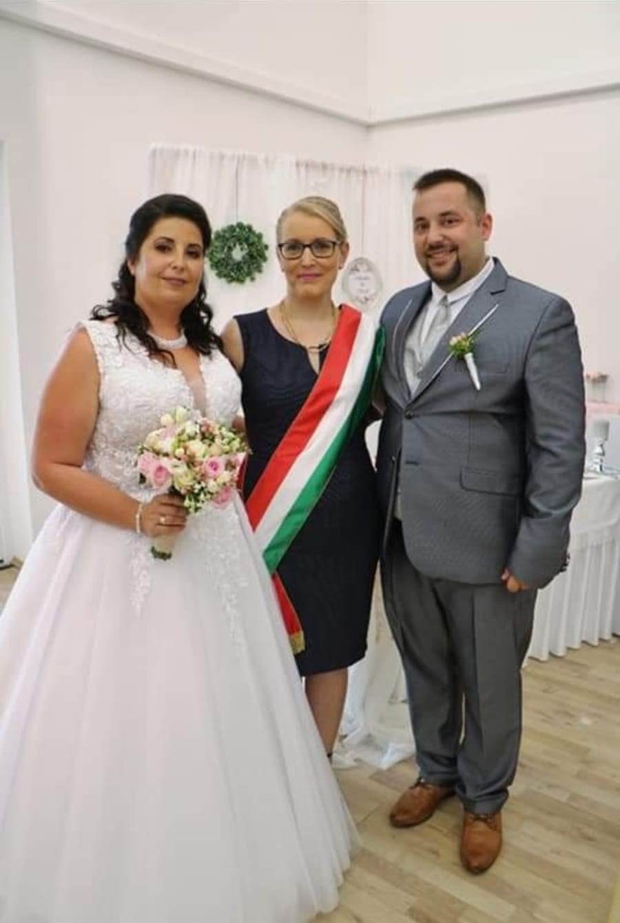 A pár és a szertartásvezető közös, ünnepi pillanata.